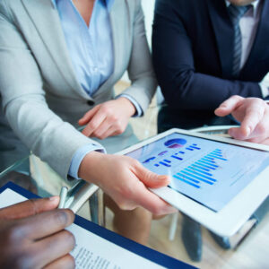 Grupa osób analizująca wykresy na tablecie