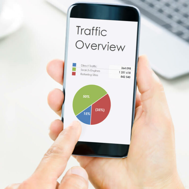 Osoba trzymająca telefon z wykresem i analizą danych