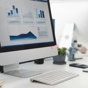 Biurko z komputerem pokazującym statystyki i wykresy