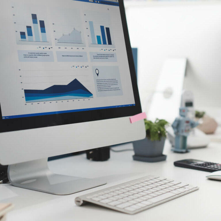 Biurko z komputerem pokazującym statystyki i wykresy