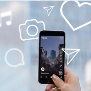 Telefon trzymany w ręce, na tle budynków