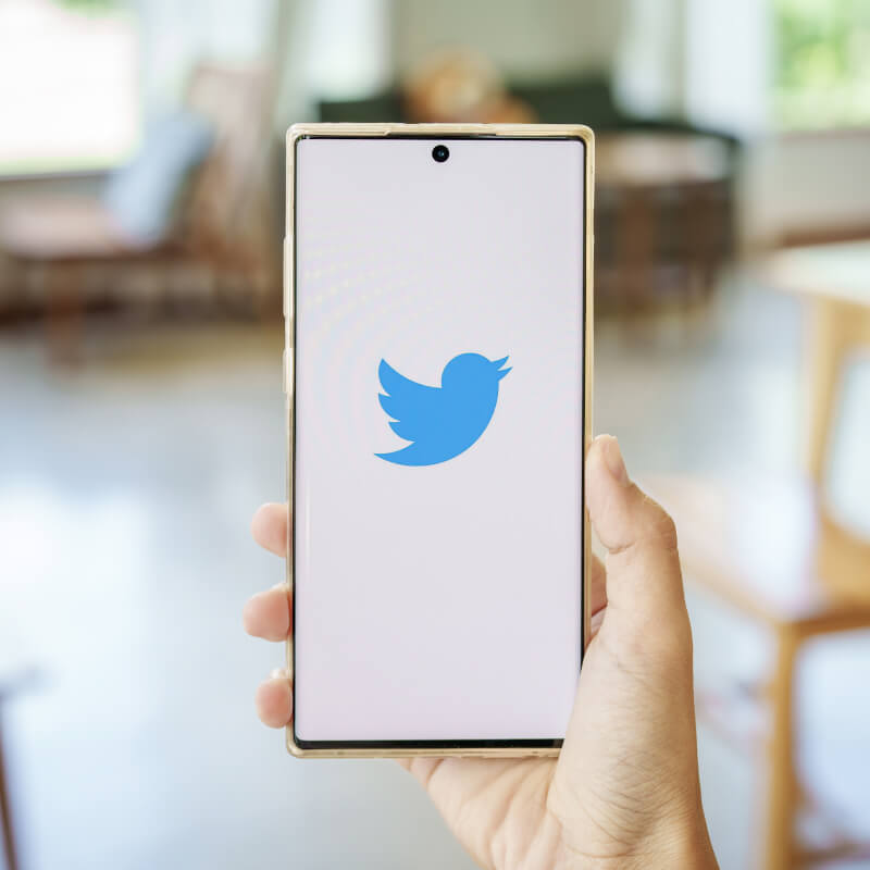 Telefon z logo Twittera trzymany w ręce