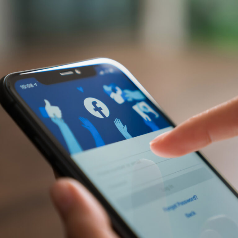 Osoba logująca się do Facebooka na telefonie