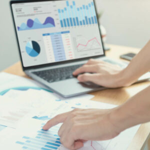 Osoba analizująca wykresy na laptopie