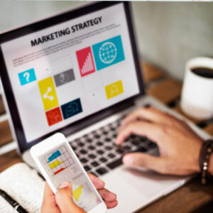 Osoba analizująca dane reklamowe na laptopie i telefonie