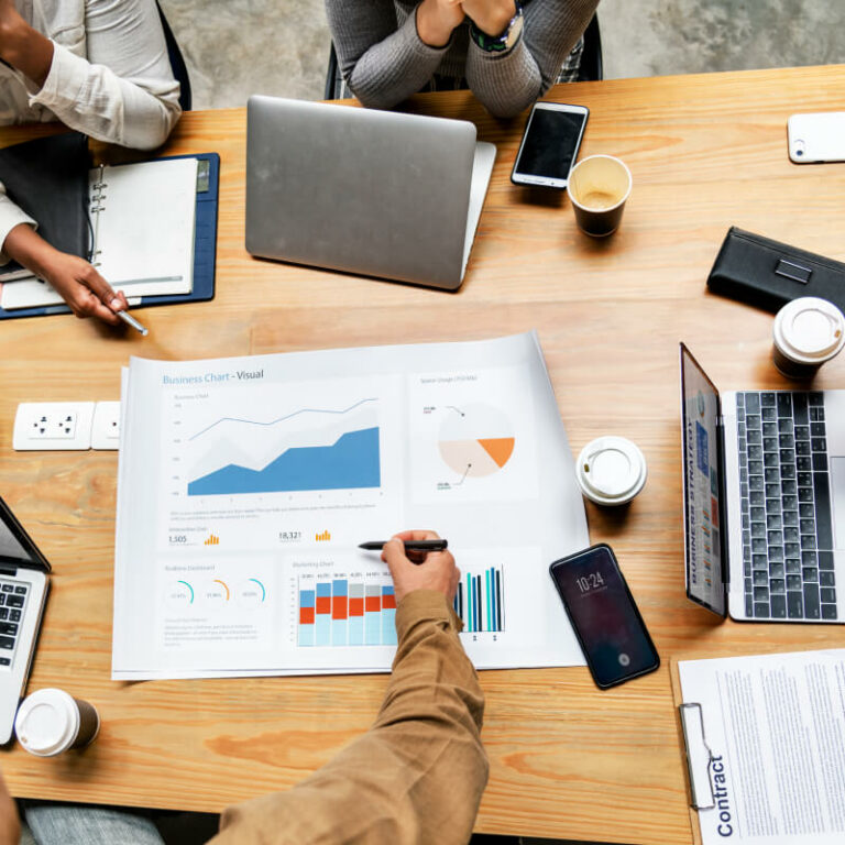 Grupa osób, analizująca wykresy przy biurku