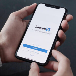 Telefon z logo LinkedIn trzymany w ręce.