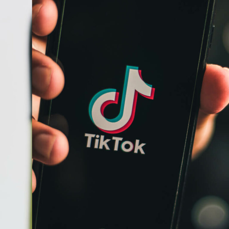 Telefon z logo TikToka, trzymany w dłoni