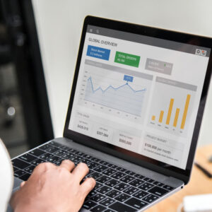 Osoba analizująca raporty na laptopie