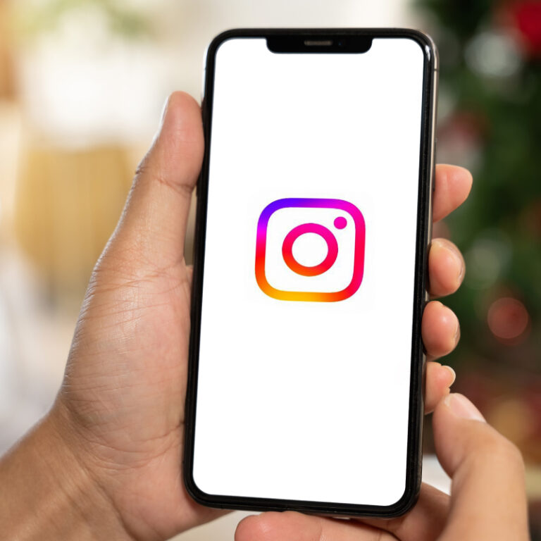 Osoba trzymająca telefon z logo Instagrama