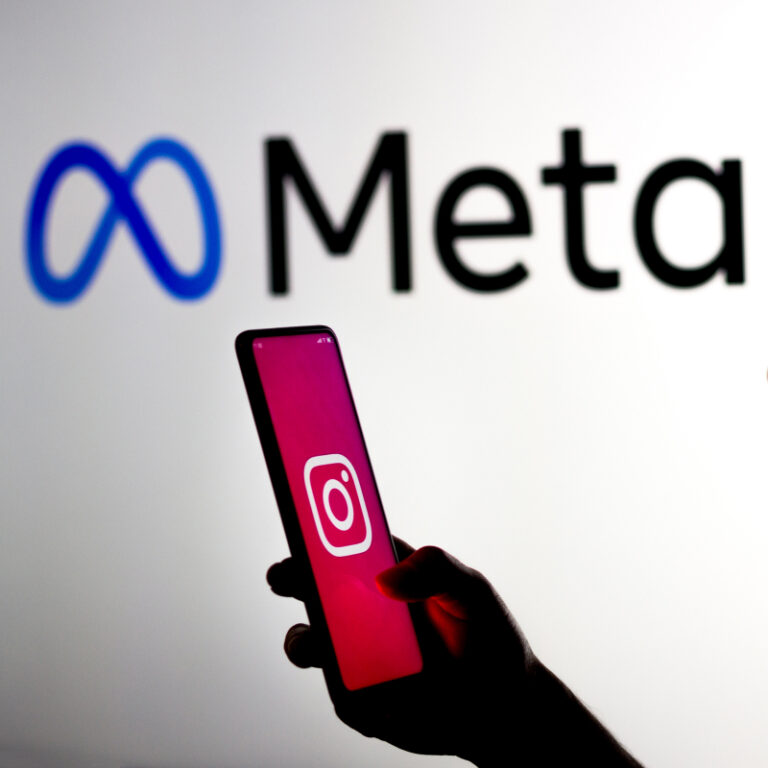 Telefon z logo Instagrama na tle dużego logo Meta