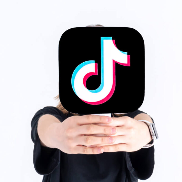 Osoba trzymająca w rękach logo TikToka