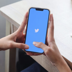 Osoba trzymająca telefon z logo aplikacji Twitter