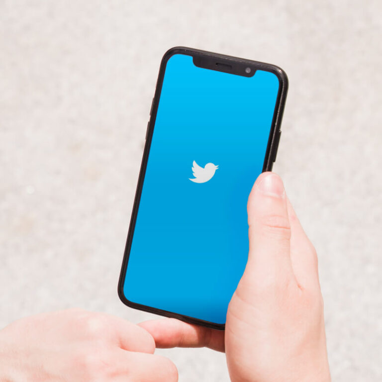 Osoba trzymająca telefon z logo aplikacji Twitter
