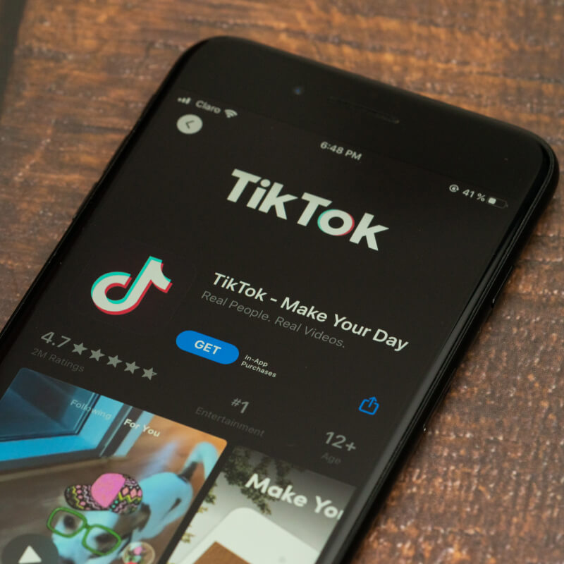 Telefon z logo aplikacji TikTok, leżący na stole