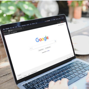 Osoba pracująca przy biurku na laptopie z logo Google na ekranie