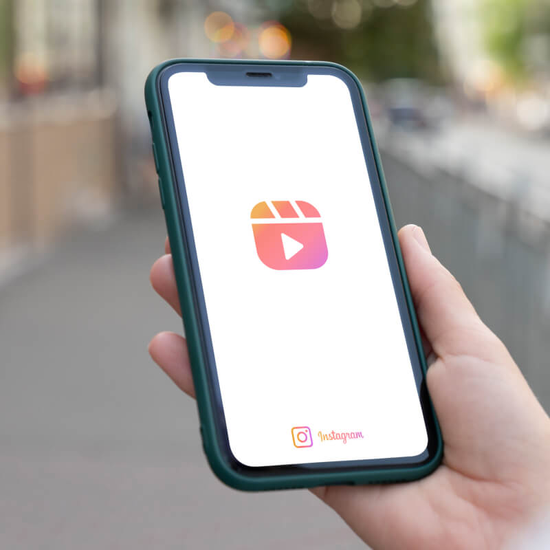 Telefon z logo Instagram Reels trzymany w dłoni