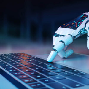 Dłoń robotra AI na klawiaturze laptopa