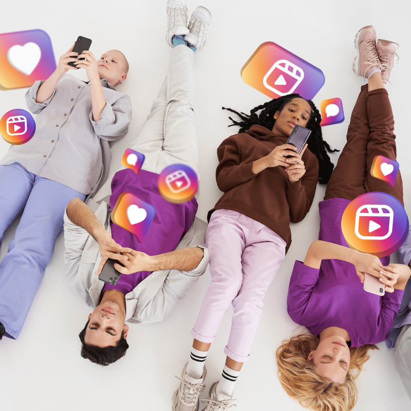 Grupa osób leżących na podłodze z telefonami w rękach i grafikami z aplikacji Instagram dookoła