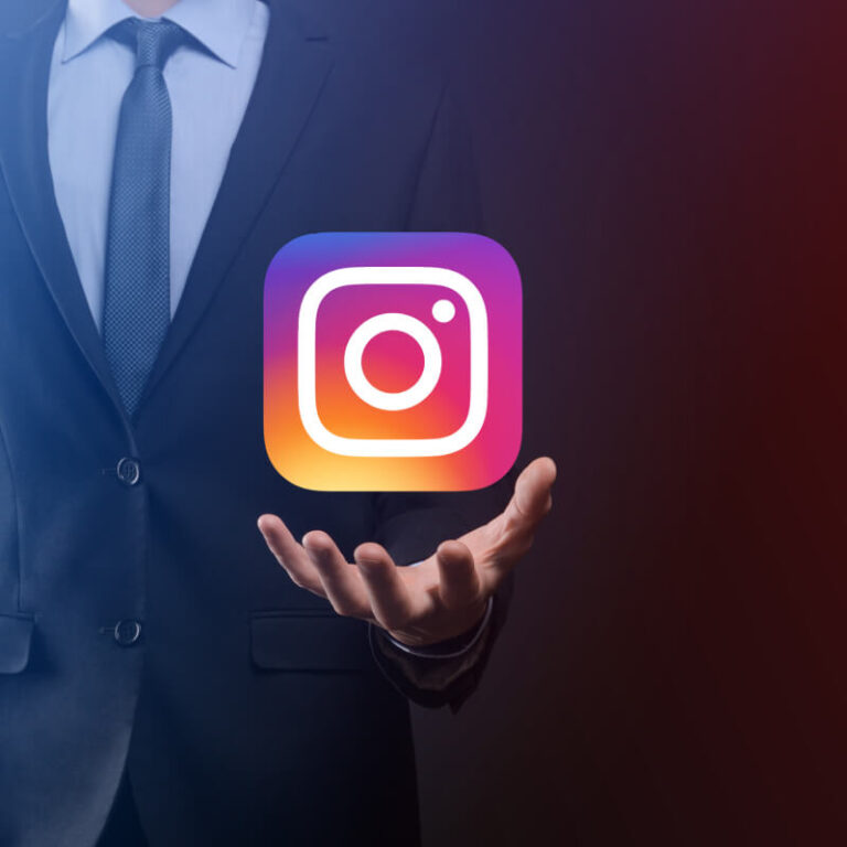 Osoba w garniturze, nad której dłonią wisi logo aplikacji Instagram