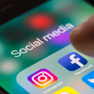 Ekran telefonu z logo aplikacji Instagram i Facebook w folderze social media