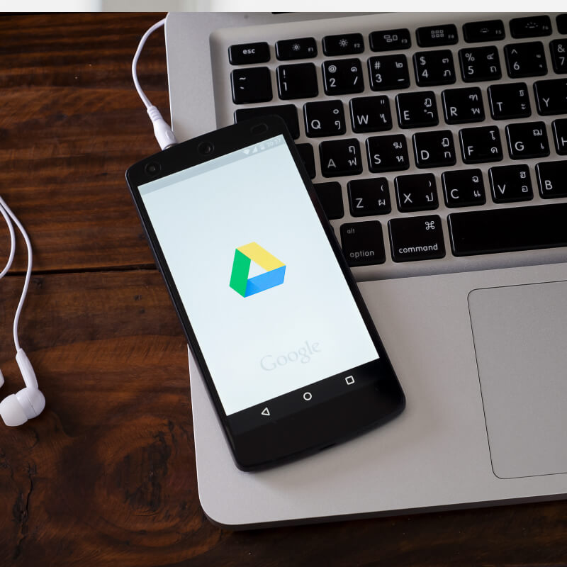 Telefon z logo Google Ads leżący na laptopie